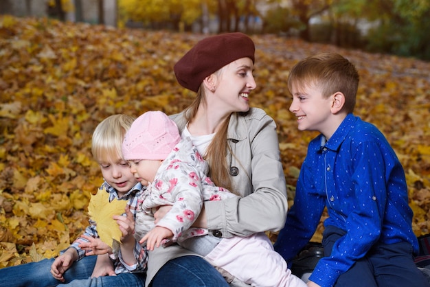 Matka i troje dzieci w parku jesień. Duża szczęśliwa rodzina. Rodzeństwo.