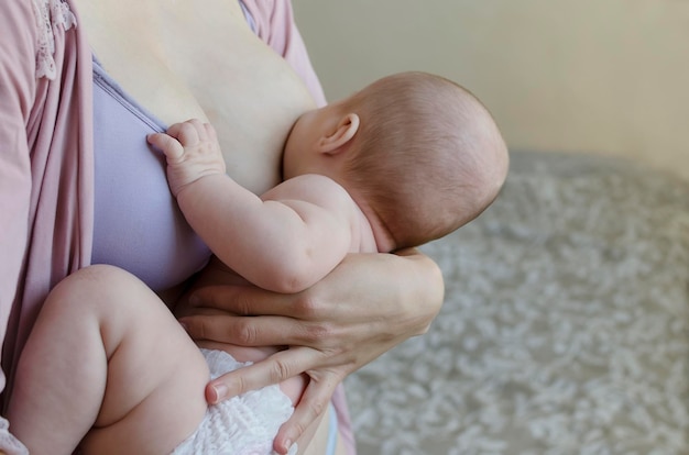 Matka karmi piersią noworodka zbliżenie w sypialni Miękkie światło macierzyństwo karmienie piersią c