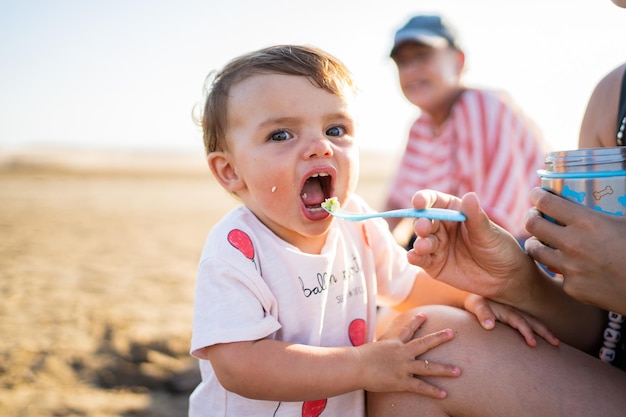 Matka karmiąca dziecko na plaży podczas zachodu słońca