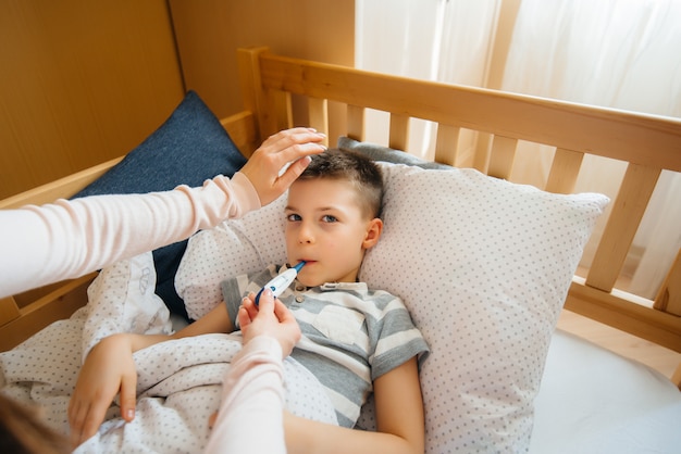 Matka Opiekuje Się Dzieckiem, Które Ma Gorączkę I Gorączkę. Choroba I Opieka Zdrowotna