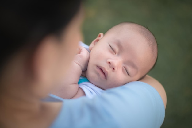 Zdjęcie matka przytulająca dziecko lub mama trzymająca w ręku niemowlę śpiące