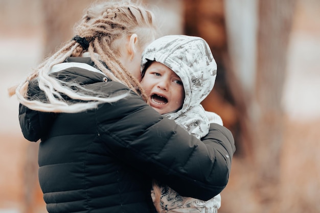 Zdjęcie matka trzymająca płaczące dziecko smutny mały chłopiec uściskany przez matkę