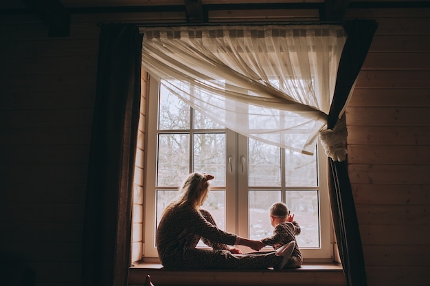 Matka z dzieckiem siedzi przy oknie i gry