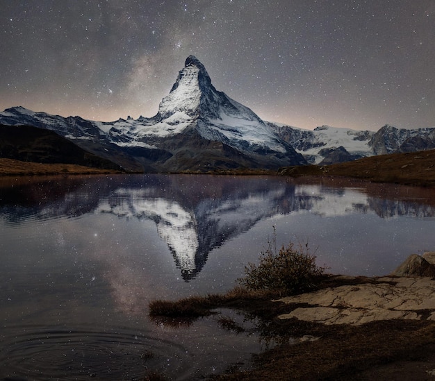 Matterhorn i Droga Mleczna odbijają się w jeziorze stellisee.