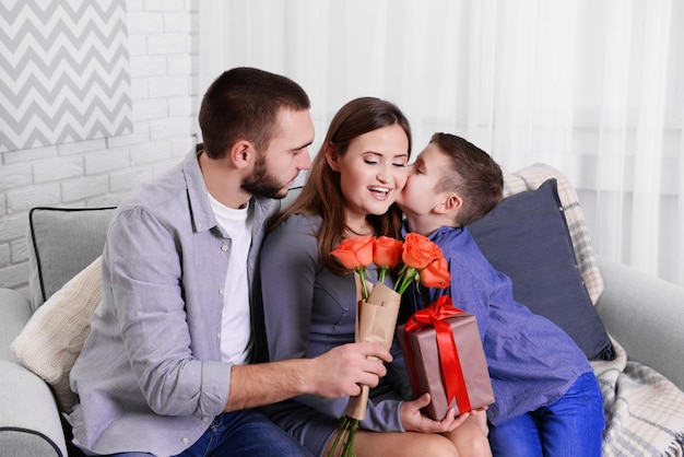 Mąż i syn rozdający żonie pudełko i róże