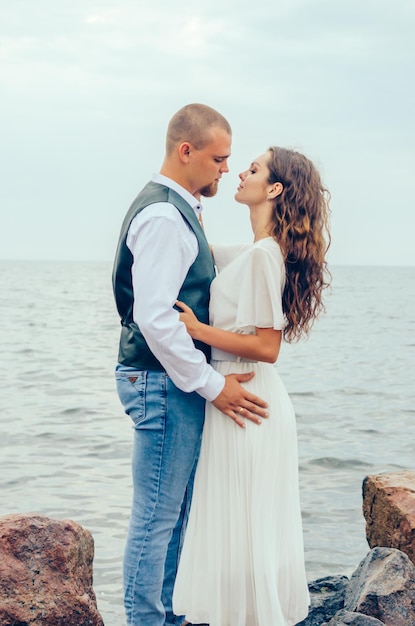 mąż i żona przytulają się na skałach nad morzem Miesiąc miodowy