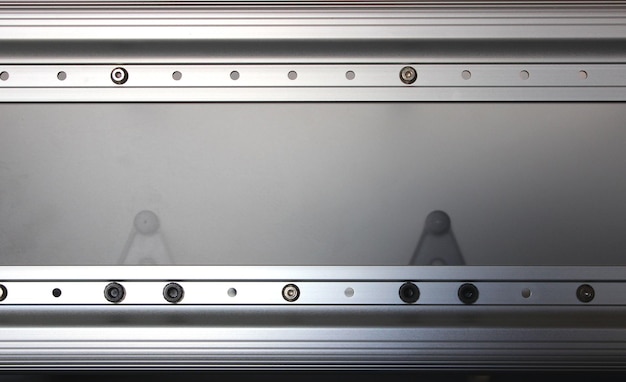 Mechaniczne tło półprzezroczystego panelu i aluminiowych szyn z otworami montażowymi