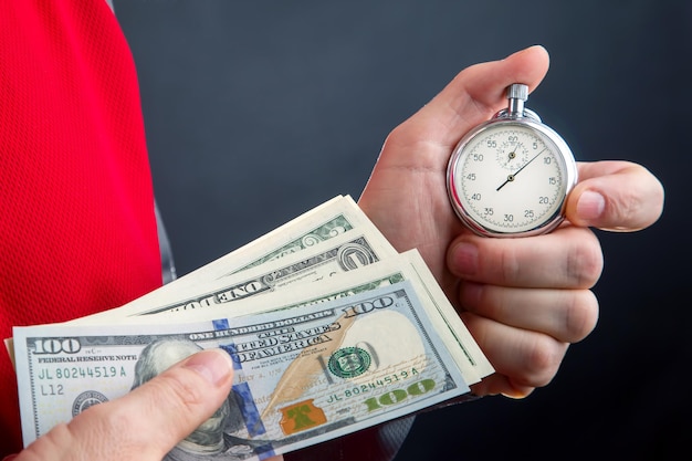 Mechaniczny stoper analogowy i dolary w dłoni biznesmena Dokładność w niepełnym wymiarze godzin dla biznesu i finansów