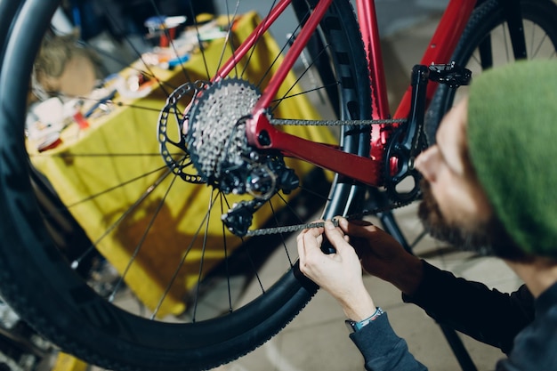 Mechanik mechanik montujący niestandardowy łańcuch instalacyjny roweru w warsztacie