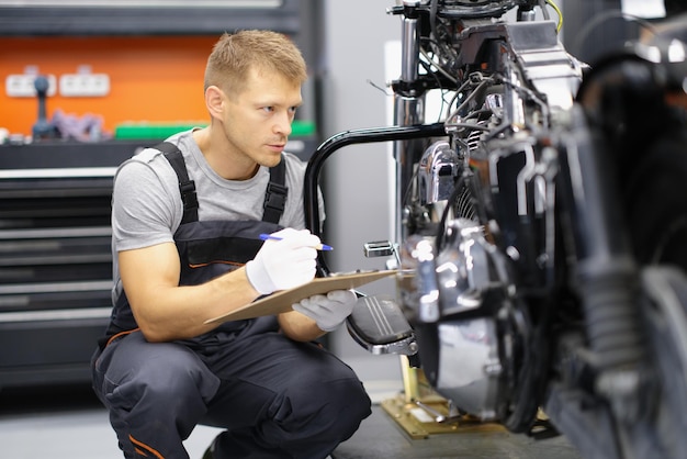 Mechanik motocyklowy robi notatki, zbliżenie