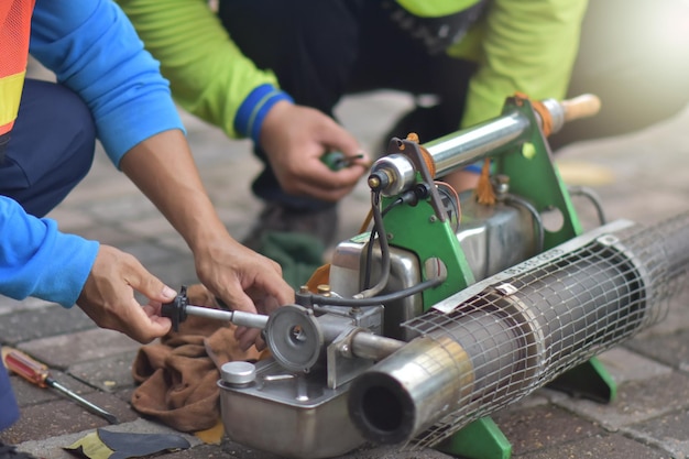 Mechanik naprawia maszynę opryskującą komary w celu przygotowania do sprayu na komaryxA