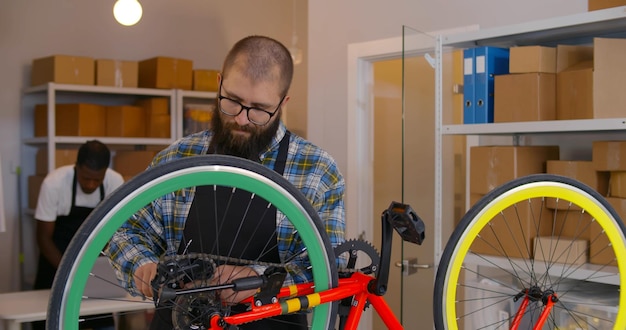 Mechanik rowerowy mocujący koło rowerowe w warsztacie