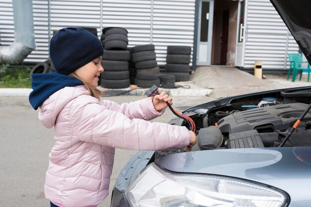 Mechanik samochodowy dla dzieci zmieniający okablowanie w serwisie samochodowym