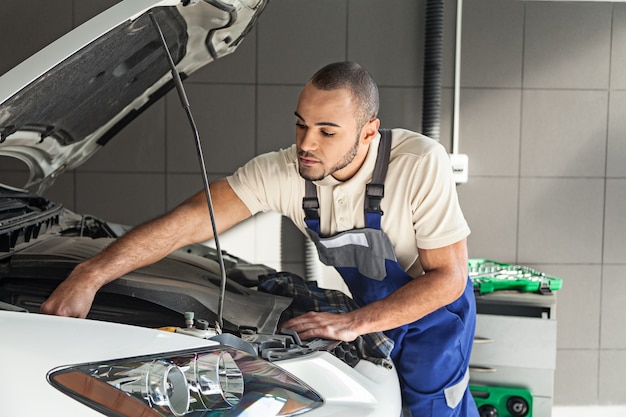 Mechanik samochodowy sprawdzający silnik samochodu