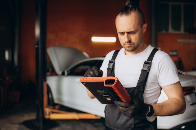 Mechanik używający tabletu w samochodzie w garażu