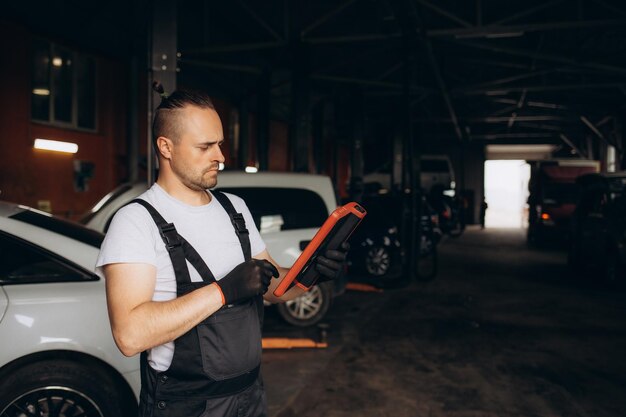 Mechanik używający tabletu w samochodzie w garażu