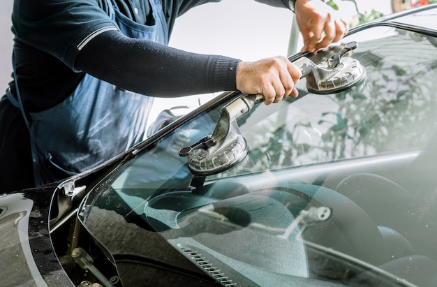 Mechanik Zmieniający Zepsutą Szybę I Szybę Samochodową Lub Zamiennik Białego Samochodu W Auto Repair Shop