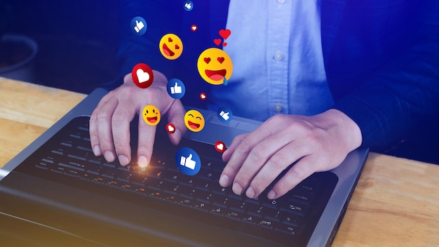 Media społecznościowe i cyfrowa koncepcja online Biznesmen za pomocą laptopa wysyłający emotikony za pomocą mediów społecznościowych
