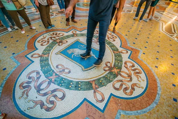 Mediolan, Włochy - 11 czerwca 2017: Wnętrze Galleria Vittorio Emanuele Ii i Mozaika byka w podłodze w Mediolanie w Mediolanie.