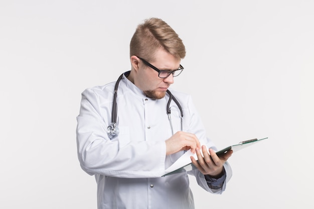 Medycyna I Koncepcja Zdrowia - Lekarz Uśmiecha Się Ze Stetoskopem, Trzymając Folder Dokumentu Na Białym Tle