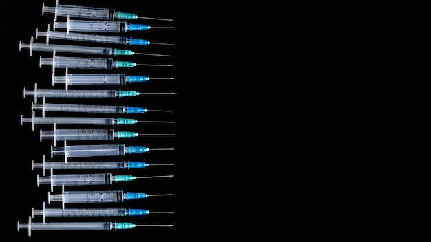 Medyczne strzykawki z igłą na czarnym tle z bliska strzykawki