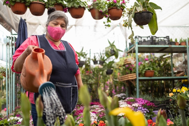 Meksykańska Kobieta Podlewa Rośliny W Szkółce Xochimilco W Meksyku, Ma Na Sobie Maskę, Nowy Normalny