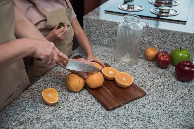 Meksykańska matka i córka przygotowują sok pomarańczowy w kuchni