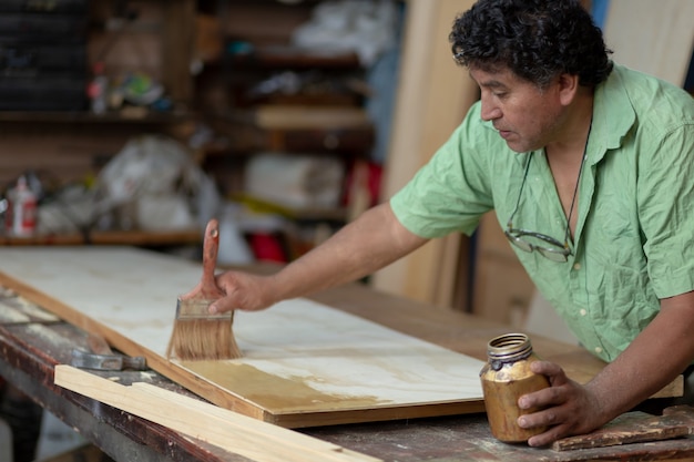 Meksykański stolarz, stolarz lakierujący w swoim warsztacie