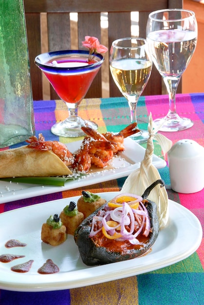 Meksykański talerz z chile relleno i taco z krewetkami na stole z typowym meksykańskim kolorowym jedzeniem