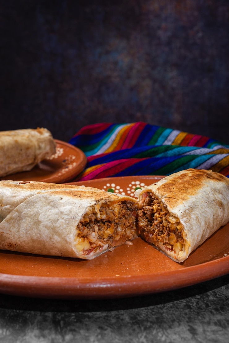 Zdjęcie meksykańskie burrito pokrojone na glinianym talerzu meksykańskie fast foody