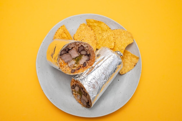 Meksykańskie burrito z wołowiną na małym talerzu z frytkami nachos