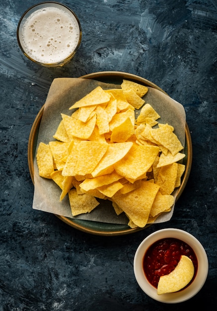 Meksykańskie nachos z pomidorowym sosem keczupowym. Koncepcja kuchni meksykańskiej. Żółte kukurydziane chipsy totopos z sosem