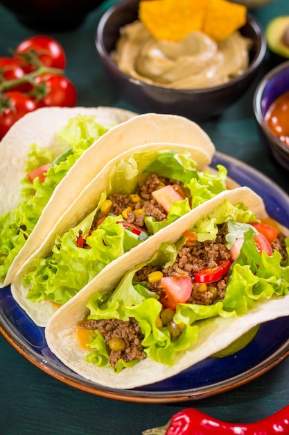 Meksykańskie Tacos Z Mięsem, Fasolą, Kukurydzą, Salsą I Warzywami Na Talerzu. Widok Z Góry. Kuchnia Tex-mex.