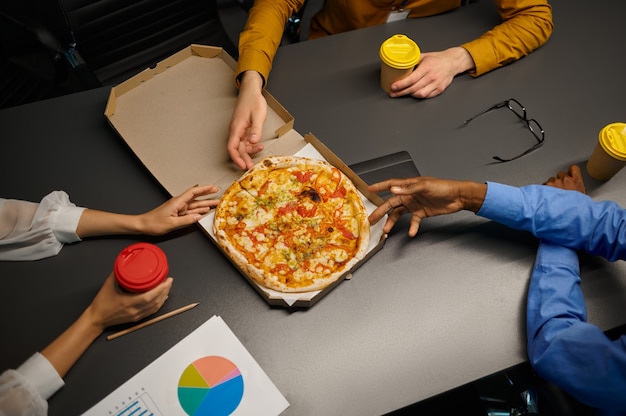 Menedżerowie jedzą pizzę, biznes lunch w biurze IT