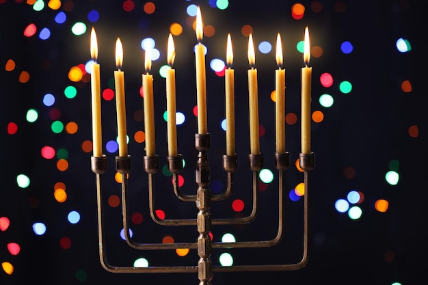 Zdjęcie menora ze świecami na chanukę na tle rozjaśnionych świateł