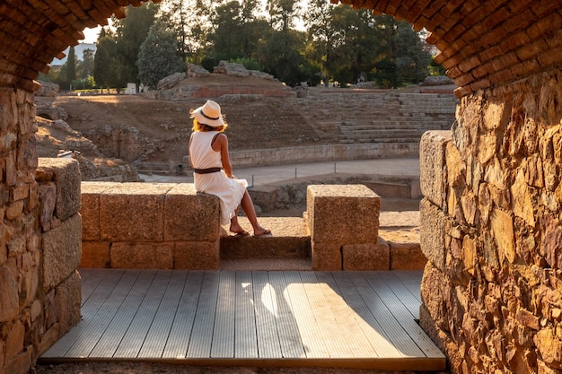 Merida Roman Rujnuje młodą kobietę siedzącą i patrzącą na rzymski amfiteatr Estremadura