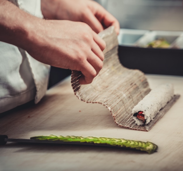 Zdjęcie męscy kucharze przygotowujący sushi w kuchni restauracji