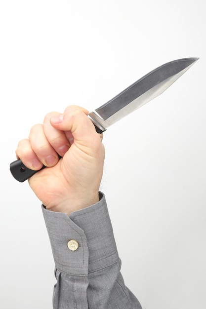 Męska ręka trzyma nóż na białym tle