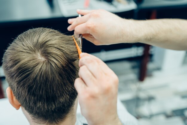 Męski fryzjer ścinający włosy klienta