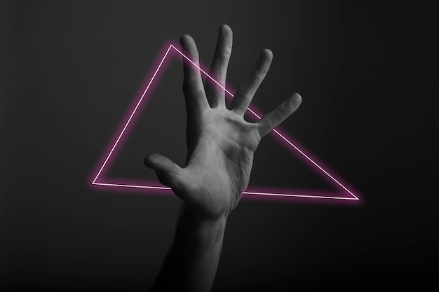 Męski gest otwartej dłoni na ciemnym tle z abstrakcyjną poświatą neonowego światła