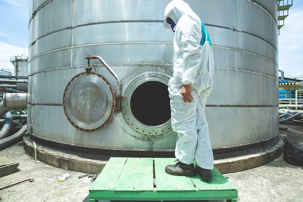 Męski pracownik kombinezonu ochronnego do włazu zbiornik paliwa ze stali nierdzewnej strefa ochrony chemicznej ograniczona przestrzeń niebezpieczna
