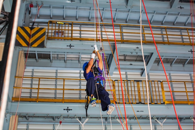 Męski pracownik treningowy liny do dostępu do liny w pracy na wysokości