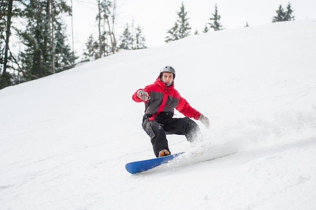 Zdjęcie męski snowboarder jazda w dół od góry w zima dniu