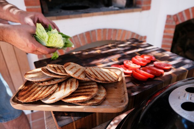 Zdjęcie męski szef kuchni wręcza przygotowywać hamburgery