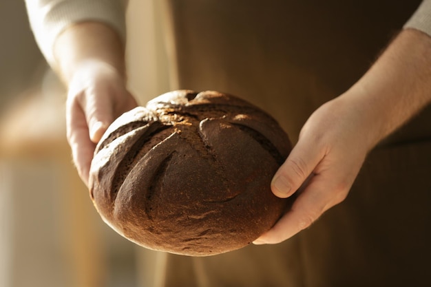 Męski szef kuchni z bochenkiem chleba zbliżenie