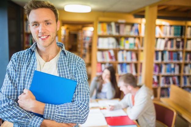 Męski uczeń z innymi w tle przy biblioteką