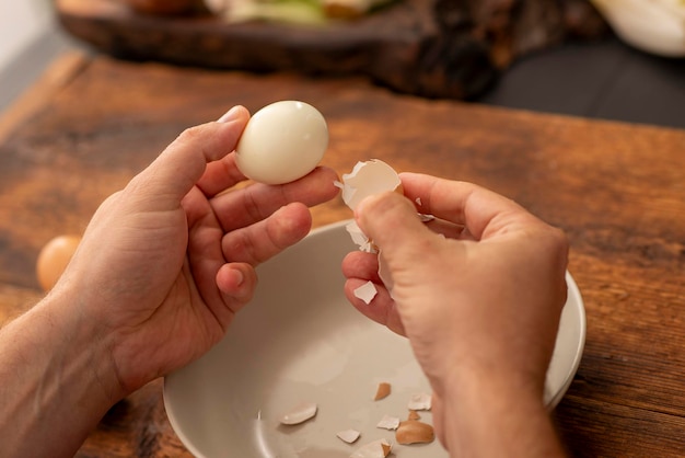 Zdjęcie męskie dłonie obierają jajka na twardo