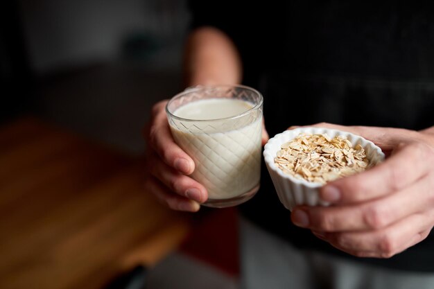 Męskie dłonie ze szklanką wegańskiego mleka Alternatywne rodzaje mleka bezmlecznego Mleko roślinne z różnych zbóż Czyste odżywianie Zdrowa dietaxA