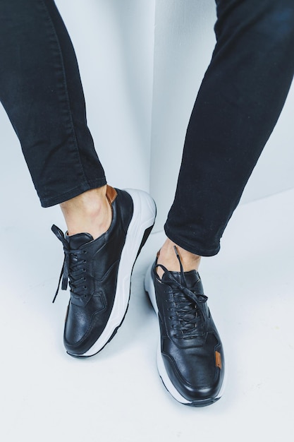 Męskie nogi w codziennych butach w kolorze czarnym wykonane z prawdziwej skóry męskie na butach w czarnych trampkach Wysokiej jakości zdjęcie