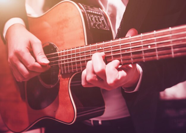Męskie ręce grające na gitarze ćwiczą grę na instrumencie